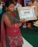 A graduate Santhal lady Receiving cash n certificate as a reward.JPG - 